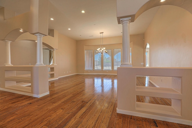 1624 23rd Ave SE, Rio Rancho, NM 87124 - unfurnished living room with wood finished floors, recessed lighting, a chandelier, ornate columns, and baseboards