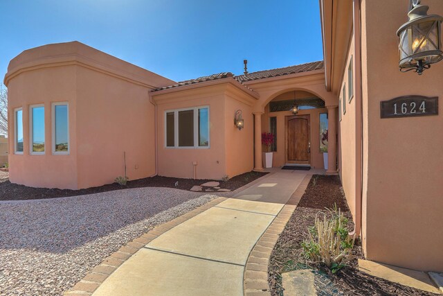 1624 23rd Ave SE, Rio Rancho, NM 87124 - property entrance with a tiled roof and stucco siding