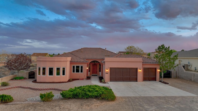 1624 23rd Ave SE, Rio Rancho, NM 87124 - mediterranean / spanish-style home featuring a tiled roof, a garage, driveway, and stucco siding