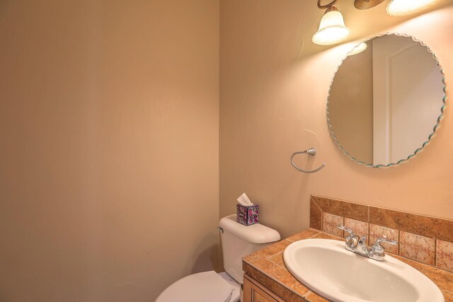 1624 23rd Ave SE, Rio Rancho, NM 87124 - half bath featuring toilet, vanity, and tasteful backsplash