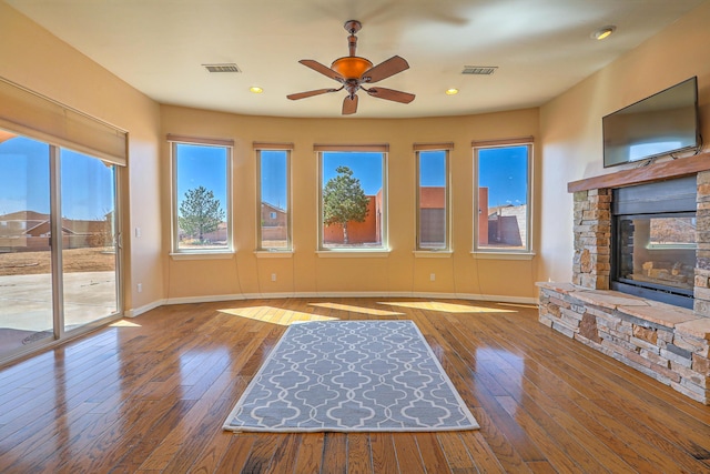 1624 23rd Ave SE, Rio Rancho, NM 87124 - unfurnished living room featuring a ceiling fan, baseboards, a stone fireplace, wood-type flooring, and recessed lighting