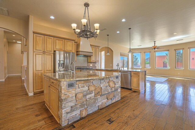 1624 23rd Ave SE, Rio Rancho, NM 87124 - kitchen with appliances with stainless steel finishes, arched walkways, dark wood-style flooring, a center island with sink, and a ceiling fan