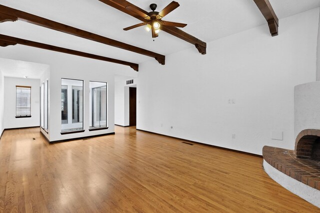 10017 Boulder St NW, Albuquerque, NM 87114 - unfurnished living room featuring beamed ceiling, a fireplace, light wood-style flooring, and ceiling fan