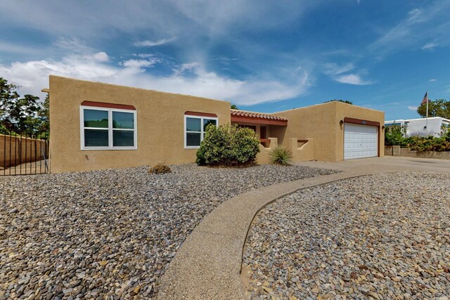 10017 Boulder St NW, Albuquerque, NM 87114 - adobe home with stucco siding, a garage, and concrete driveway