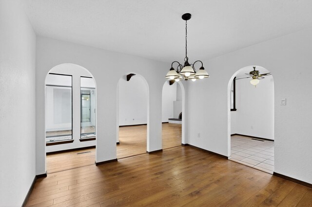 10017 Boulder St NW, Albuquerque, NM 87114 - unfurnished dining area with arched walkways, ceiling fan, hardwood / wood-style flooring, and a chandelier