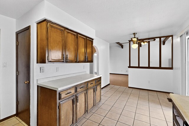 10017 Boulder St NW, Albuquerque, NM 87114 - kitchen featuring arched walkways, light countertops, a ceiling fan, and light tile patterned floors