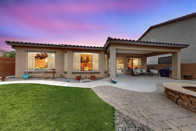 4028 Colina Roja Ln NE, Rio Rancho, NM 87124 - back of house at dusk with stucco siding, a patio, a tile roof, and an outdoor hangout area