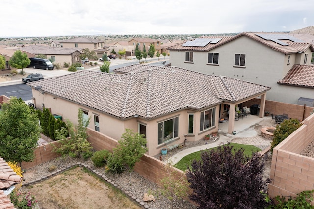 4028 Colina Roja Ln NE, Rio Rancho, NM 87124 - rear view of property with a tiled roof, stucco siding, a fenced backyard, solar panels, and a residential view