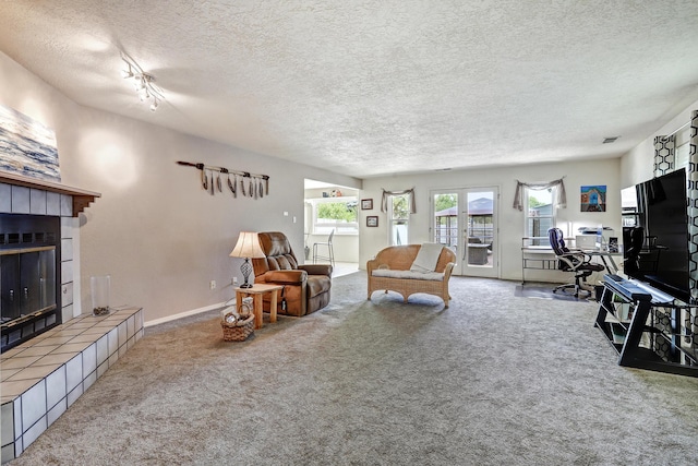12323 Haines Ave NE, Albuquerque, NM 87112 - carpeted living area with a tiled fireplace, a textured ceiling, a desk, and baseboards
