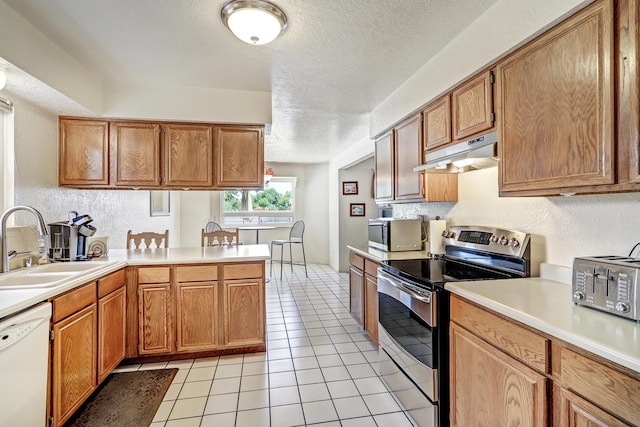 12323 Haines Ave NE, Albuquerque, NM 87112 - kitchen with appliances with stainless steel finishes, under cabinet range hood, a sink, a textured ceiling, and light countertops