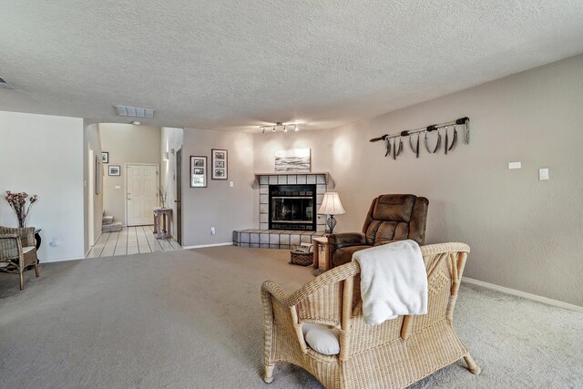 12323 Haines Ave NE, Albuquerque, NM 87112 - living area with carpet flooring, a tile fireplace, baseboards, and a textured ceiling