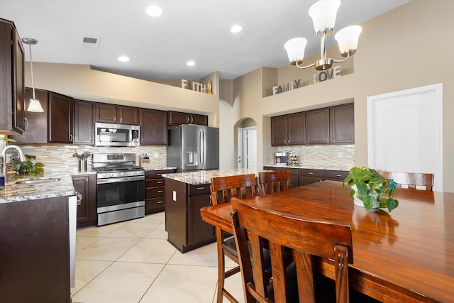8031 Corn Mountain Pl NW, Albuquerque, NM 87114 - kitchen with stainless steel appliances, a sink, arched walkways, and dark brown cabinetry