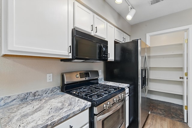 4801 Irving Blvd NW Unit 3604, Albuquerque, NM 87114 - kitchen with appliances with stainless steel finishes, white cabinets, wood finished floors, and light stone counters