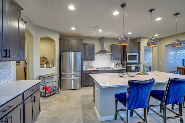 2350 Sandra Loop NE, Rio Rancho, NM 87144 - kitchen with appliances with stainless steel finishes, wall chimney range hood, tasteful backsplash, a kitchen bar, and light countertops