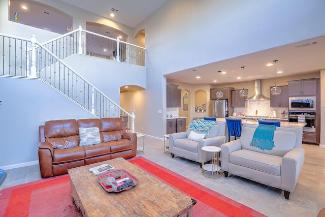 2350 Sandra Loop NE, Rio Rancho, NM 87144 - living area with arched walkways, baseboards, recessed lighting, a towering ceiling, and light tile patterned floors