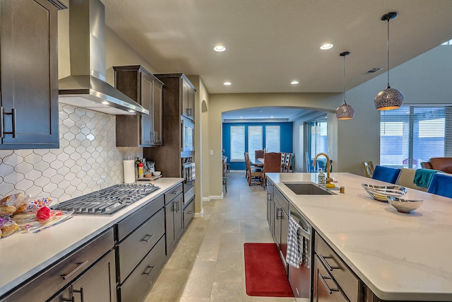 2350 Sandra Loop NE, Rio Rancho, NM 87144 - kitchen with wall chimney range hood, appliances with stainless steel finishes, arched walkways, a sink, and tasteful backsplash