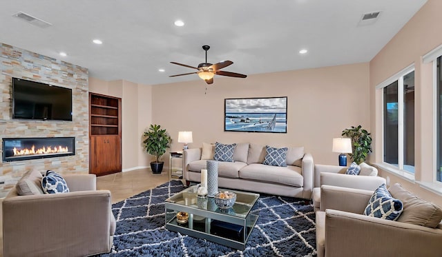 4281 Palo Verde Ct, Los Lunas, NM 87031 - tiled living room with a ceiling fan, recessed lighting, a stone fireplace, built in features, and baseboards