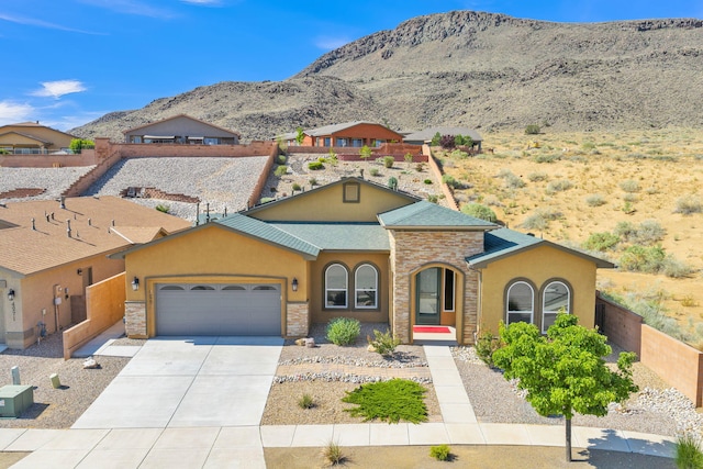 4281 Palo Verde Ct, Los Lunas, NM 87031 - view of front facade with a mountain view, an attached garage, stucco siding, and stone siding