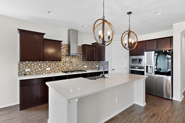 275 Adeline Ave, Los Lunas, NM 87031 - kitchen with appliances with stainless steel finishes, wall chimney exhaust hood, a chandelier, wood finished floors, and recessed lighting