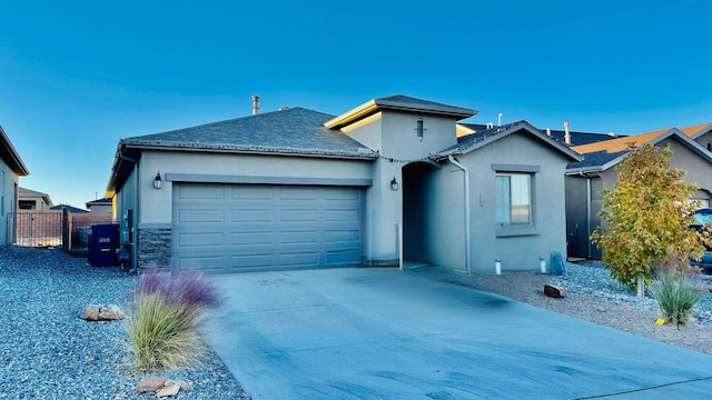 395 Adeline Ave, Los Lunas, NM 87031 - view of front of property with an attached garage, stucco siding, concrete driveway, and stone siding