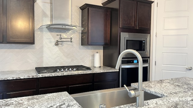 395 Adeline Ave, Los Lunas, NM 87031 - kitchen featuring ventilation hood, appliances with stainless steel finishes, decorative backsplash, and dark brown cabinets