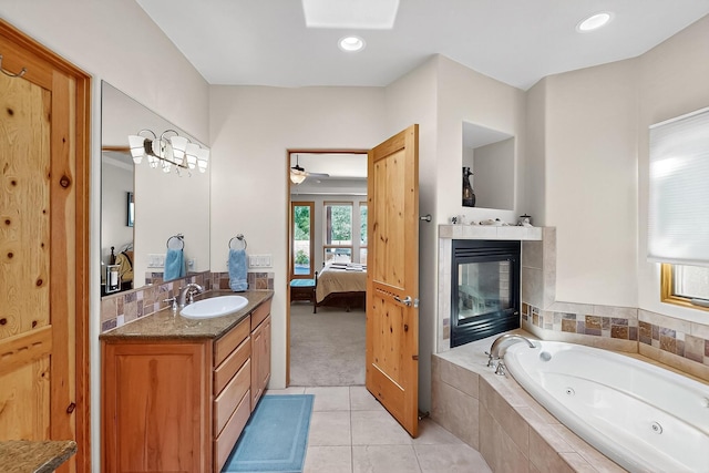 317 Plaza Muchomas, Bernalillo, NM 87004 - full bathroom with ensuite bath, a tub with jets, vanity, tile patterned flooring, and a fireplace