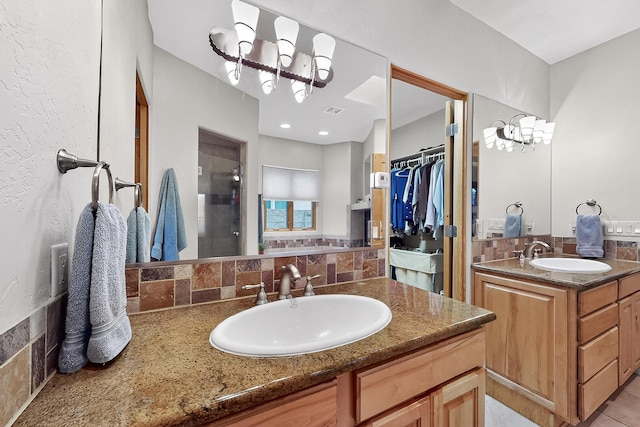 317 Plaza Muchomas, Bernalillo, NM 87004 - full bath featuring a chandelier, a stall shower, two vanities, tasteful backsplash, and a walk in closet