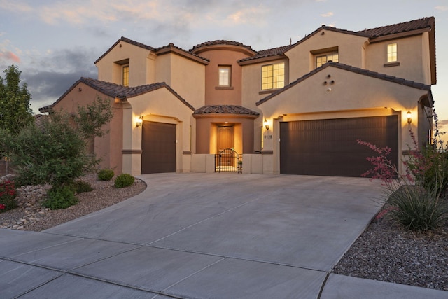 9128 Vista Bosquejo Rd NW, Albuquerque, NM 87120 - mediterranean / spanish house with a garage, driveway, a tiled roof, and stucco siding