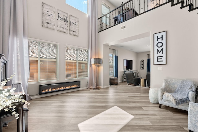 9128 Vista Bosquejo Rd NW, Albuquerque, NM 87120 - living area featuring wood finished floors, a high ceiling, and a fireplace