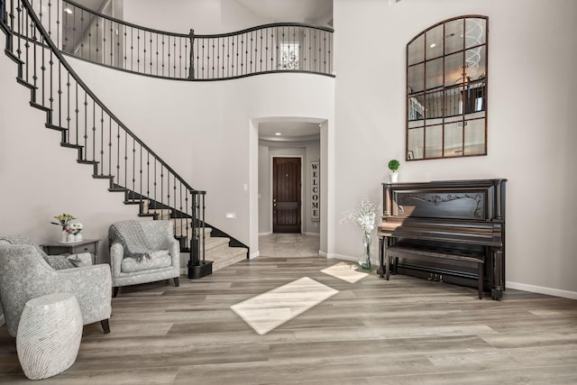 9128 Vista Bosquejo Rd NW, Albuquerque, NM 87120 - foyer entrance featuring arched walkways, stairs, wood finished floors, and a high ceiling