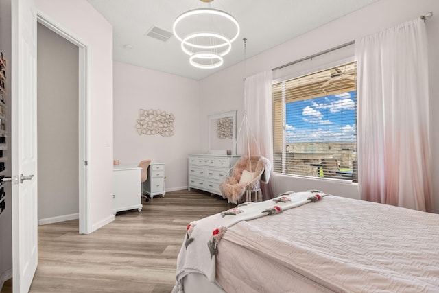 9128 Vista Bosquejo Rd NW, Albuquerque, NM 87120 - bedroom featuring wood finished floors and a chandelier
