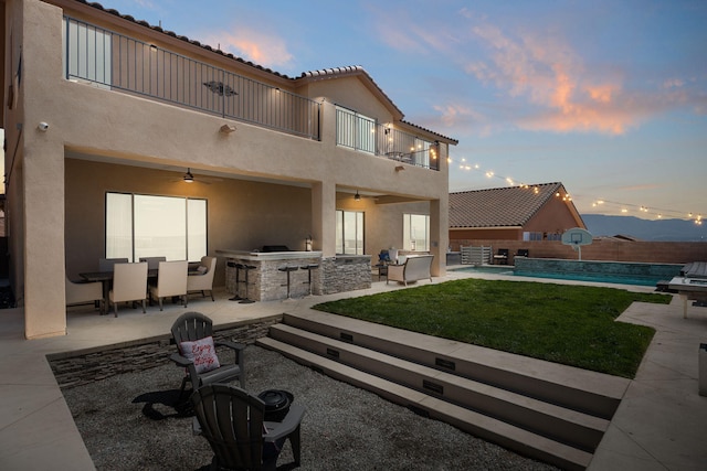 9128 Vista Bosquejo Rd NW, Albuquerque, NM 87120 - back of house with a balcony, exterior kitchen, a ceiling fan, and a patio