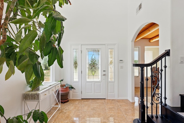 2061 Blaylock Ln NE, Los Lunas, NM 87031 - foyer entrance with beam ceiling, light tile patterned flooring, arched walkways, and stairway