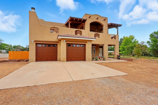 2061 Blaylock Ln NE, Los Lunas, NM 87031 - southwest-style home with a balcony, concrete driveway, stucco siding, and a tile roof