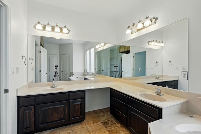 2061 Blaylock Ln NE, Los Lunas, NM 87031 - full bath featuring double vanity, a tub, and stone finish flooring