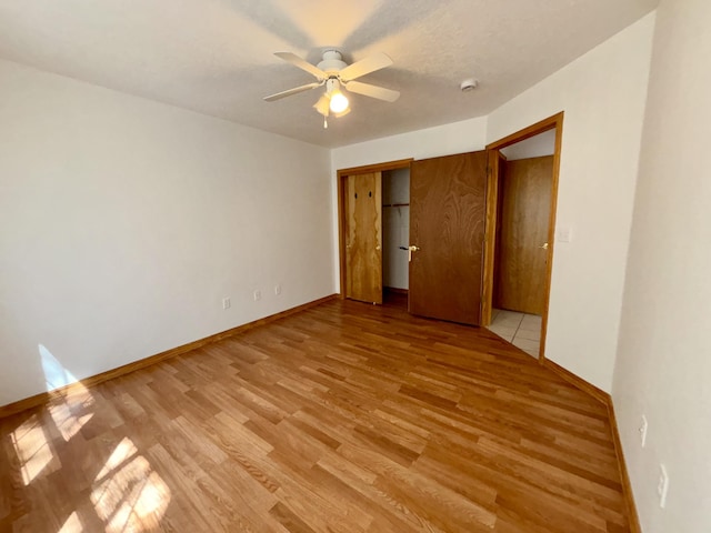 2172 Sonora Rd NE, Rio Rancho, NM 87144 - unfurnished bedroom featuring light wood-type flooring, baseboards, a ceiling fan, and a closet
