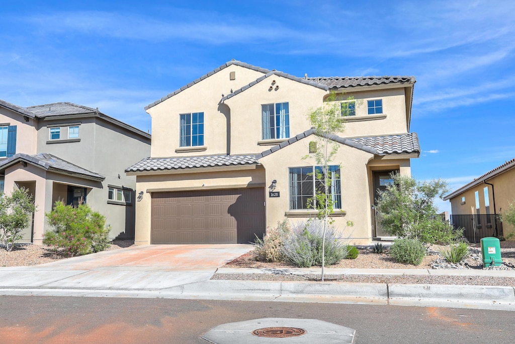 1628 Mammoth Way, Albuquerque, NM 87120 - mediterranean / spanish-style home with a tiled roof, a garage, concrete driveway, and stucco siding