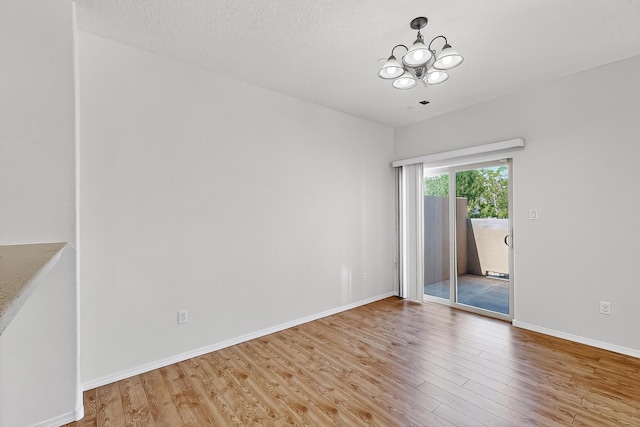 11024 Fort Point Ln NE Unit B, Albuquerque, NM 87123 - empty room with wood finished floors, a chandelier, and baseboards