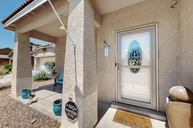 805 Palo Duro Dr, Bernalillo, NM 87004 - view of exterior entry with stucco siding, a patio, and a tiled roof