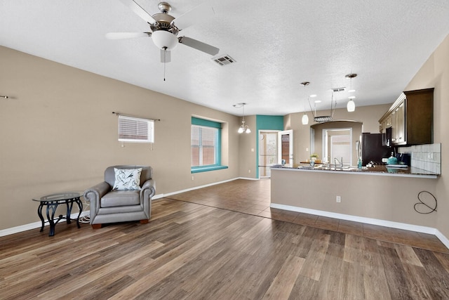 805 Palo Duro Dr, Bernalillo, NM 87004 - kitchen with dark wood-style flooring, ceiling fan, open floor plan, a peninsula, and freestanding refrigerator