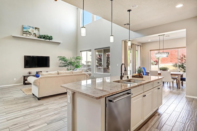 843 Mesa Roja Trl NE, Rio Rancho, NM 87124 - kitchen featuring stainless steel dishwasher, a sink, light wood-style flooring, an island with sink, and recessed lighting