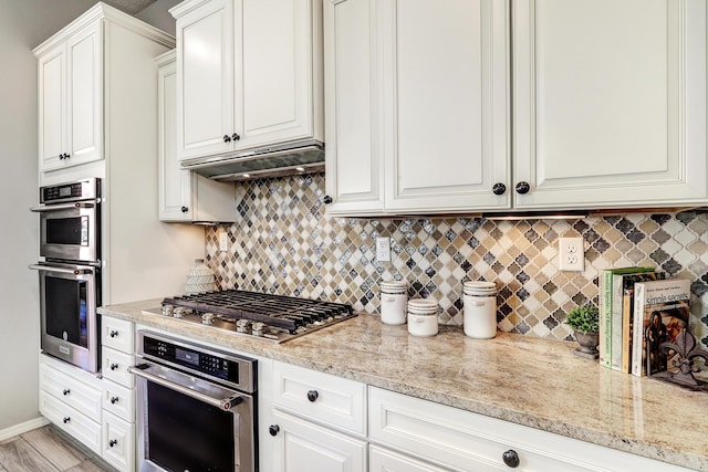 843 Mesa Roja Trl NE, Rio Rancho, NM 87124 - kitchen with appliances with stainless steel finishes, backsplash, and white cabinetry
