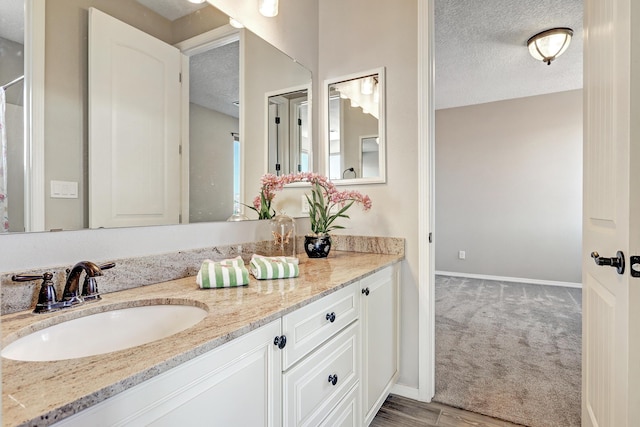 843 Mesa Roja Trl NE, Rio Rancho, NM 87124 - bathroom with a textured ceiling, double vanity, and baseboards