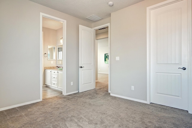 843 Mesa Roja Trl NE, Rio Rancho, NM 87124 - unfurnished bedroom with carpet floors, baseboards, a textured ceiling, ensuite bath, and a closet