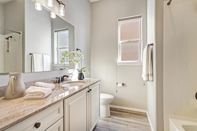 843 Mesa Roja Trl NE, Rio Rancho, NM 87124 - bathroom featuring vanity, toilet, baseboards, wood finished floors, and shower / washtub combination