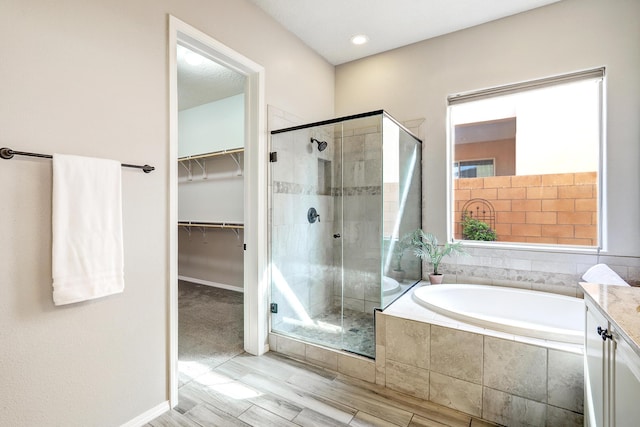 843 Mesa Roja Trl NE, Rio Rancho, NM 87124 - bathroom with a shower stall, a bath, a walk in closet, vanity, and baseboards