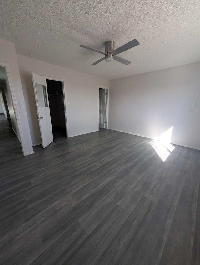 301 Stagecoach Dr, Elephant Butte, NM 87935 - unfurnished bedroom with dark wood finished floors, a textured ceiling, baseboards, and ceiling fan