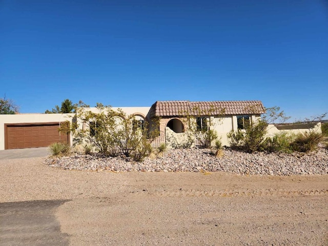 301 Stagecoach Dr, Elephant Butte, NM 87935 - view of front of house featuring stucco siding, an attached garage, driveway, and a tiled roof