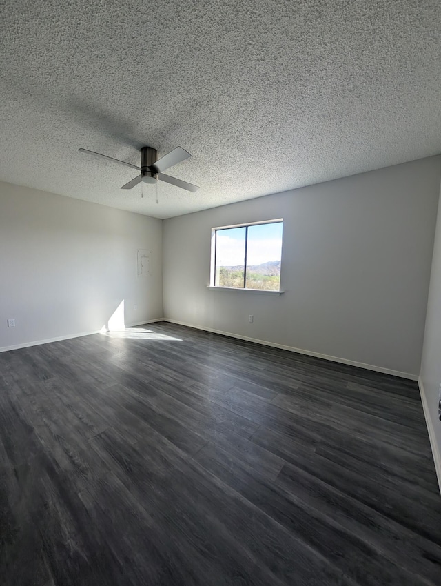 301 Stagecoach Dr, Elephant Butte, NM 87935 - spare room featuring ceiling fan, dark wood finished floors, a textured ceiling, and baseboards
