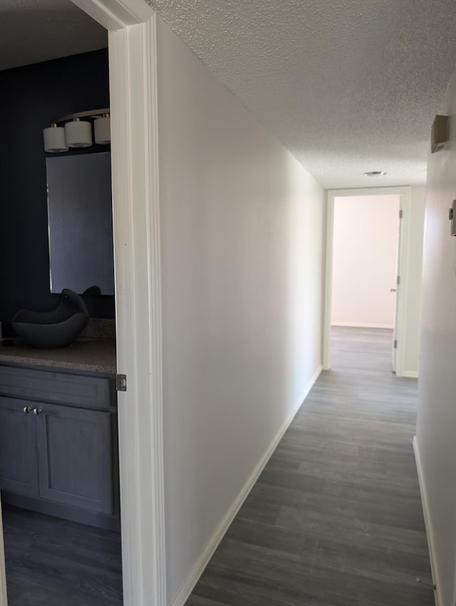 301 Stagecoach Dr, Elephant Butte, NM 87935 - hall with a textured ceiling, baseboards, dark wood-type flooring, and a sink